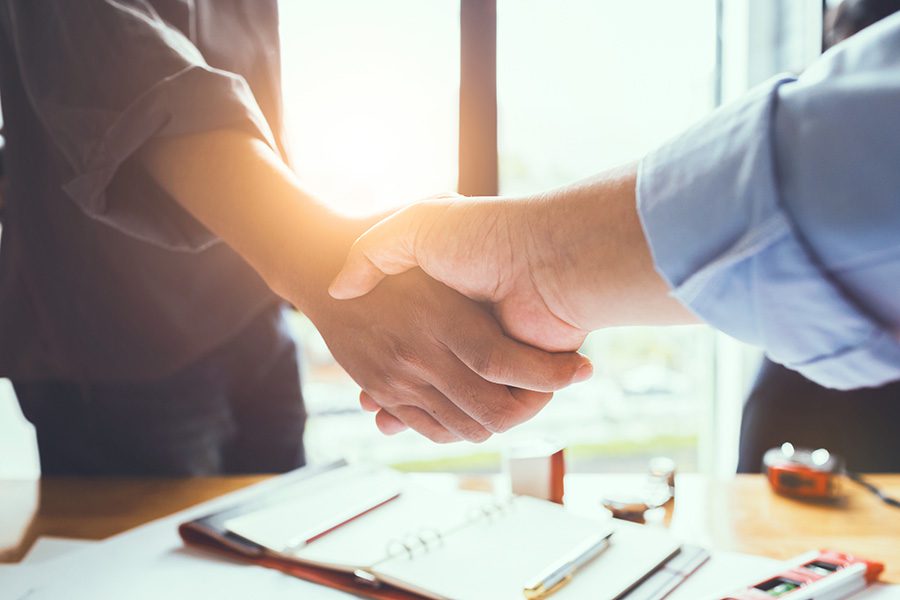 Pledge of Performance - Firm Business Handshake Between Two Business Colleagues Having a Meeting in the Office